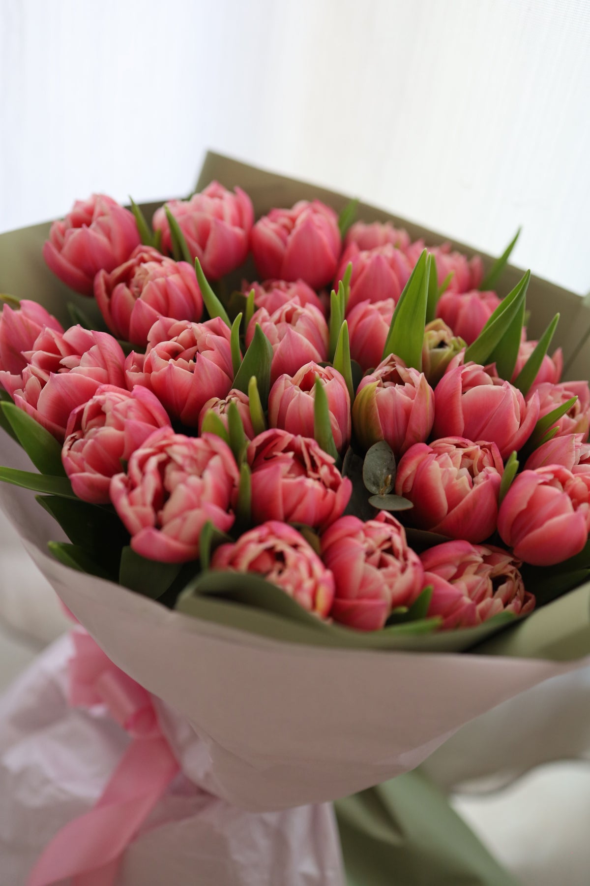 Blush Tulips — double-petaled pink tulip bouquet wrapped in kraft paper with a blush ribbon